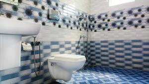 a blue tiled bathroom with a toilet and a sink at Marari Praise Beachfront Homestay in Mararikulam