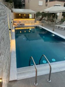 a large swimming pool with blue water in a building at Rizos Bay Sarakiniko in Sarakiniko