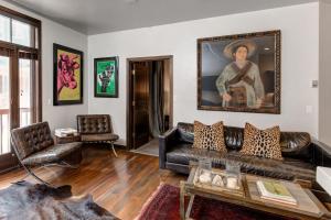 a living room with a leather couch and a painting on the wall at LIFT LODGE 102 condo in Park City
