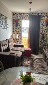 ein Wohnzimmer mit einer Couch und einem Glastisch in der Unterkunft Quarto em apartamento compartilhado em Ananindeua in Ananindeua