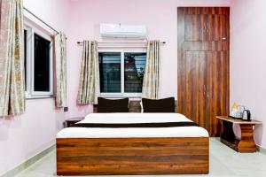 ラーンチーにあるHotel O Ritushreeのベッドと窓のある寝室