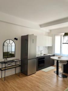 Una cocina con refrigerador de acero inoxidable y una mesa. en Plinio 72 Apartment, en Milán 32 fotos más