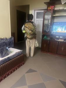 a person standing in a living room watching a television at Alara Hostel ' Only girls ' in Naj‘ al Maḩaţţah