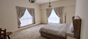a bedroom with a bed and two windows at JBR Skyview Rooms in Dubai +73 photos