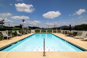a swimming pool with chairs and a table at Hillside Hotel in Luray
