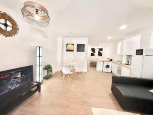 a living room with a black couch and a kitchen at Renfe Asamblea de Madrid 03 AMCH Hospedaje in Madrid
