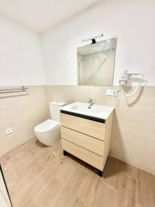 a bathroom with a sink and a toilet and a mirror at Renfe Asamblea de Madrid 03 AMCH Hospedaje in Madrid