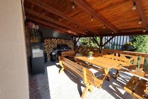 a patio with wooden tables and benches and a grill at Zagrodek Premium Spa in Gródek Nad Dunajcem
