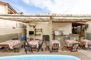 a patio with tables and chairs and a kitchen at Pousada beira-mar ilhabela in Ilhabela