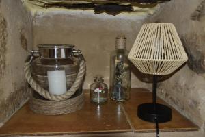 a candle and a lamp on a shelf with a candle at Casa rural El Carmen in Baños de la Encina +47 photos
