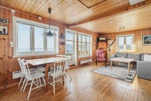 a living room with a table and chairs and a couch at Eagle Point Lofoten in Eggum