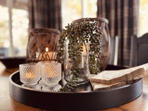 a tray with glass vases and candles on a table at Harmony in Geilo, modern and cozy cabin in Geilo
