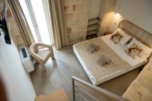 a small bedroom with a bed and a chair at Dimora Negli Archi in Monopoli