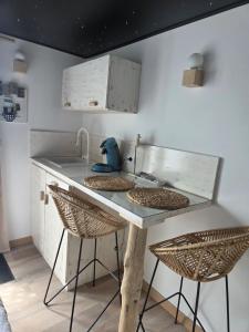 a kitchen with a sink and two stools at Le studi'eau in Ferques