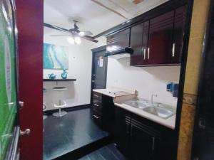 a kitchen with a sink and a ceiling fan at Hotel Garcias Suites, Linares in Linares