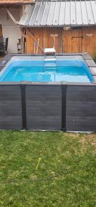 a swimming pool with a chair in a yard at Къща за гости РАДЕЯ in Govedartsi