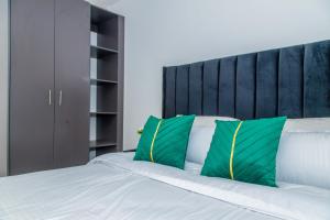 KisiiMilly's Haven Homes的卧室里有一张床,上面有绿色和白色的枕头