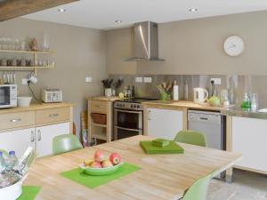 Una cocina con una mesa con un bol de fruta encima. en West Barn, en Chesterfield