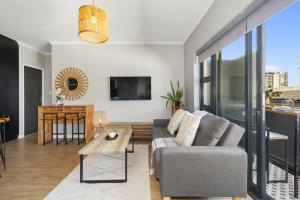 a living room with a couch and a table at Cape on Porterfield Unit 5 by Host Agents in Bloubergstrand