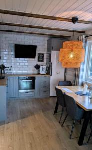 una cucina con tavolo con sedie e frigorifero di Discover the ultimate aurora escape with a cozy outdoor sauna and hot tub a Karlsøy Altre 88 foto