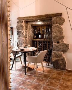 a dining room with a table and a wine cellar at Casa As Fontes in Porqueirós