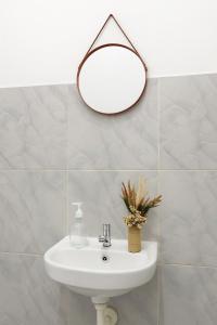 a bathroom with a sink and a mirror on the wall at Casa De' Summer Banyuwangi in Banyuwangi