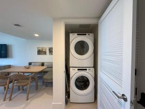 a washer and dryer in a room with a table at Downtown Miami view - 38th floor gem in Miami +11 photos
