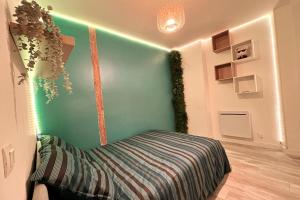 a room with a bed with a green wall at Le 136 B in Grenoble