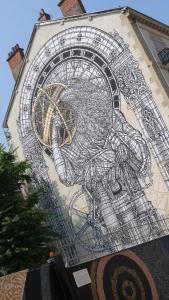 a building with a drawing of a clock on it at Le 136 B in Grenoble