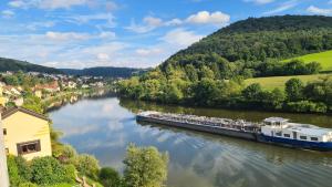 a boat traveling down a river with people on it at Haides helle Wohnung in Neckarsteinach