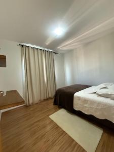 a bedroom with a bed and a window with curtains at SUNSHINE- Centro ponta grossa in Ponta Grossa