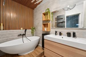 Un baño con bañera blanca y lavabo. en Appartement Design Porte de Paris avec parking, en Sèvres 19 fotos más