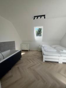 a white room with a tub and a bed and a sink at DOM za Górą in Krajno-Zagórze