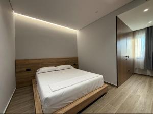 ein Schlafzimmer mit einem weißen Bett und einem Fenster in der Unterkunft Xhoil Hotel in Lushnjë + 20 Fotos