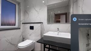 ein weißes Badezimmer mit Waschbecken und Toilette in der Unterkunft Xhoil Hotel in Lushnjë
