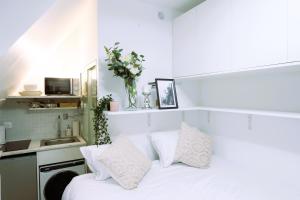 - une chambre blanche avec un lit et un lavabo dans l'établissement Studio - Tour Eiffel - Trocadéro, à Paris 22 autres photos