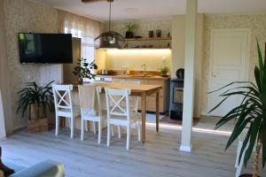 a kitchen with a wooden table and white chairs at Kärdla Retrovisiit Kirsi, Tiina ja Linda in Kärdla