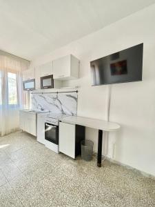 a kitchen with white cabinets and a table in it at Appartamenti Kelly e Sissi - Fucecchio, Firenze in Fucecchio +2 photos