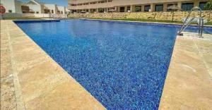 a swimming pool with blue water in front of a building at Penthouse Valle del Este Deluxe in Vera