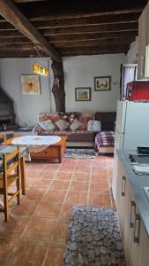 eine Küche und ein Wohnzimmer mit einer Couch und einem Tisch in der Unterkunft Corias Casona junto al Narcea in Corias