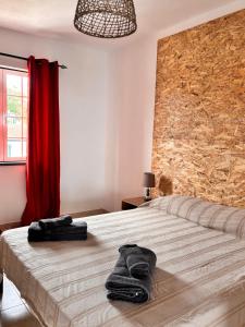 a bedroom with a large bed with a stone wall at Casa de Campos AL in Angra do Heroísmo