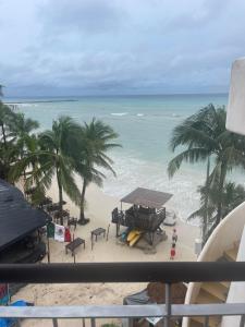 a view of the beach from the balcony of a resort at Beach Front - Ocean View 1 BR Condo w Terrace & Hughe Infinity Pool Heart of Playa del Carmen in Playa del Carmen