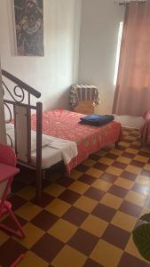 a bedroom with a bed and a checkered floor at Salerno in Chiclayo