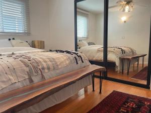 een slaapkamer met twee bedden en een grote spiegel bij Cozy Beach Bungalow- Happynest in Long Beach