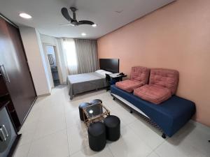 a living room with a couch and a bed at Flat completo em BH in Belo Horizonte