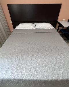 a bedroom with a bed with a black headboard at Flat completo em BH in Belo Horizonte