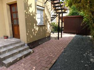 una casa con una pasarela de ladrillos al lado de una puerta en Lukács apartman, en Gyula