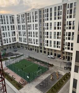 un campo da tennis di fronte a un grande edificio di Host Baku a Baku