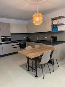 a kitchen with a wooden table and chairs at Gemini Court Apartment in Marsaxlokk