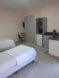 een hotelkamer met twee bedden en een keuken bij Hotel Castro Alves in Marília